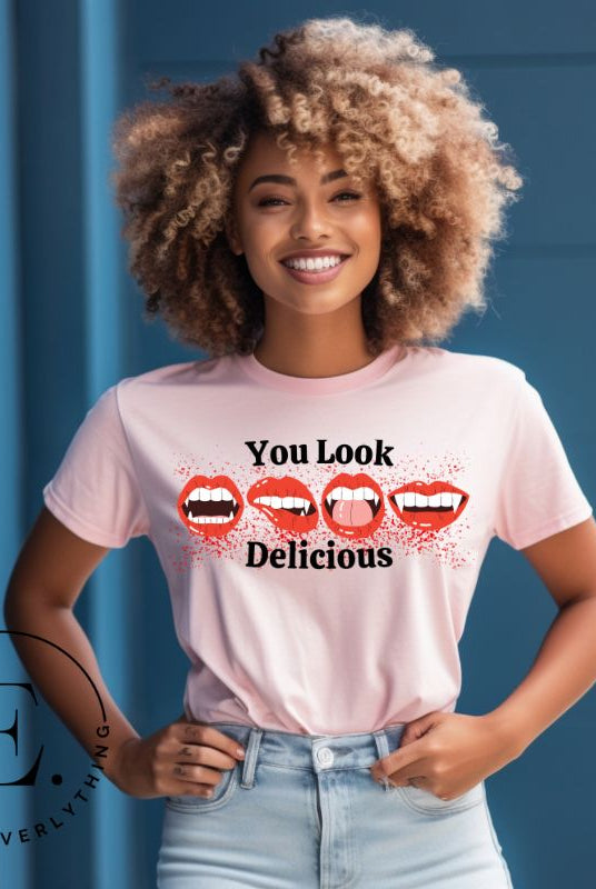 Indulge in wickedly delightful style with our vampire lips shirt. Featuring alluring lips dripping with Halloween allure, this shirt captivates with its seductive charm. The cheeky message, 'You Look Delicious,' on a pink shirt. 