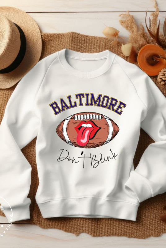Embrace your Baltimore Ravens pride with our modern and trendy sweatshirt featuring the team's name and powerful slogan, "Don't Blink." On a white sweatshirt. 