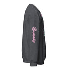 Dark Grey Gildan sweatshirt featuring a vibrant Cancer zodiac design. The front showcases an artistic representation of a woman with flowing hair adorned with a crab, surrounded by celestial elements like moons and stars, in pastel colors. The word "Cancer" is written in a stylish pink script above the design. The sleeve also has "Cancer" written vertically in matching pink script.