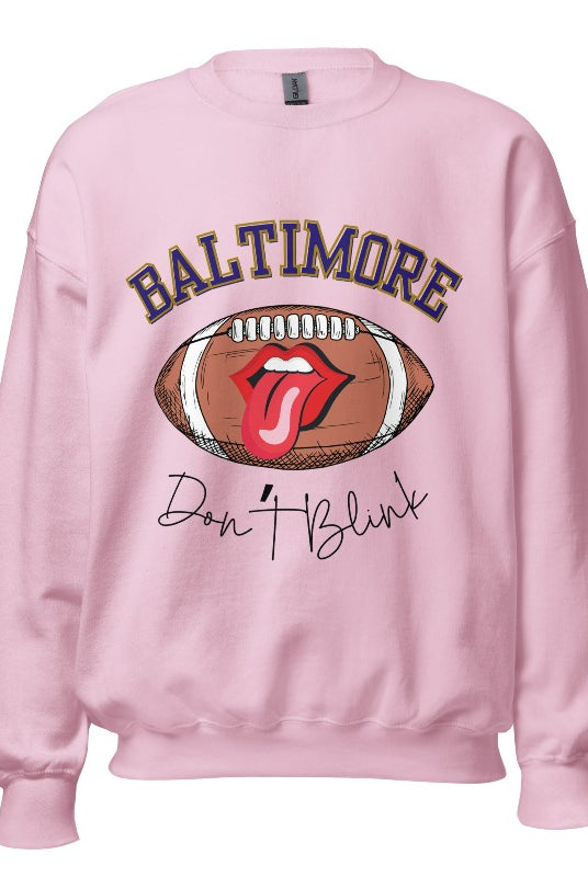 Embrace your Baltimore Ravens pride with our modern and trendy sweatshirt featuring the team's name and powerful slogan, "Don't Blink." On a light pink sweatshirt. 