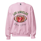 Cheer on the Los Angeles Rams in style with our exclusive sweatshirt featuring the team name and iconic slogan, "Ram House." On a light pink sweatshirt. 