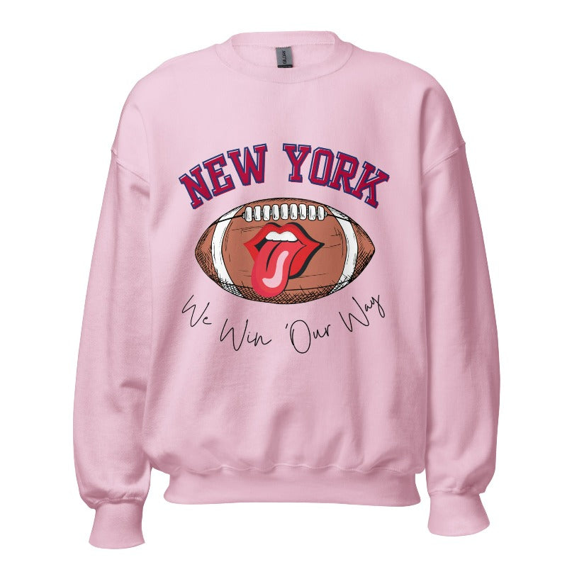 Elevate your game-day attire with this New York Giants sweatshirt, featuring a football and unique lips and tongue design. Highlighted with the team's empowering slogan "We Win Our Way" and the iconic New Yor wordmark, on a pink colored sweatshirt. 