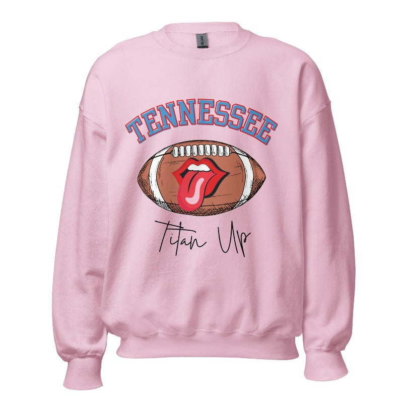 Elevate your game-day look with this Tennessee Titans sweatshirt, featuring a football and unique lips and tongue design. Complete with the team's rallying cry "Titan Up" and the iconic Tennessee wordmark, on a light pink sweatshirt. 