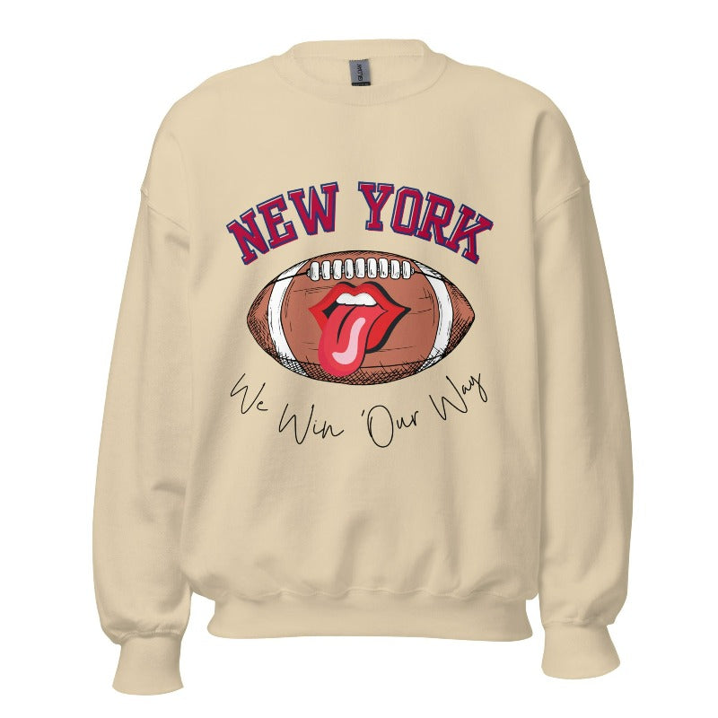 Elevate your game-day attire with this New York Giants sweatshirt, featuring a football and unique lips and tongue design. Highlighted with the team's empowering slogan "We Win Our Way" and the iconic New Yor wordmark, on a sand colored sweatshirt. 