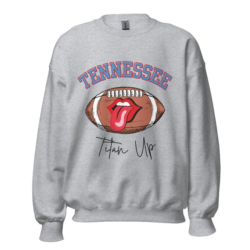 Elevate your game-day look with this Tennessee Titans sweatshirt, featuring a football and unique lips and tongue design. Complete with the team's rallying cry "Titan Up" and the iconic Tennessee wordmark, on a sports grey sweatshirt. 