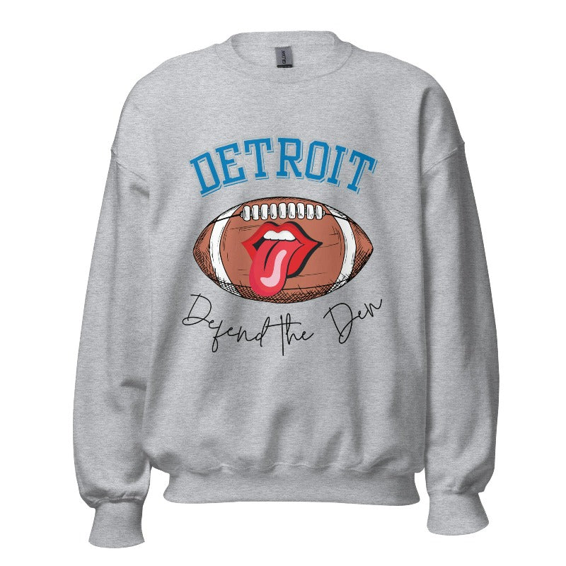 Get ready to show your Detroit Lions pride with this stylish sweatshirt featuring a football and playful lips and tongue design. Complete with the team's slogan "Defend the Den" and the iconic Detroit wordmark, this cozy grey sweatshirt. 