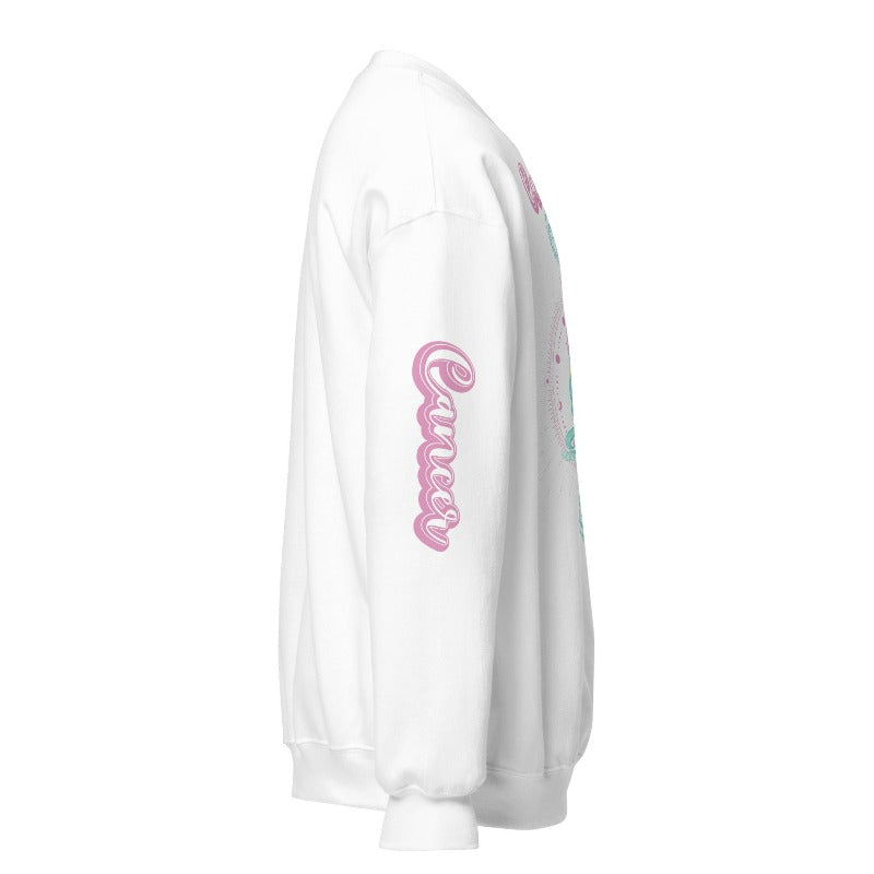 White Gildan sweatshirt featuring a vibrant Cancer zodiac design. The front showcases an artistic representation of a woman with flowing hair adorned with a crab, surrounded by celestial elements like moons and stars, in pastel colors. The word "Cancer" is written in a stylish pink script above the design. The sleeve also has "Cancer" written vertically in matching pink script.