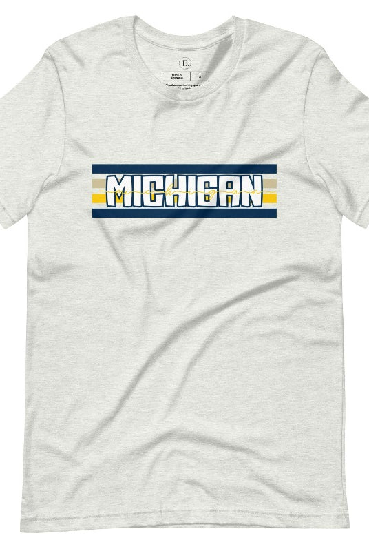 Elevate your collegiate style with our Michigan University graphic tee featuring iconic school colors and bold chest stripes. Emblazoned with "Michigan" in striking lettering, on an ash colored shirt. 