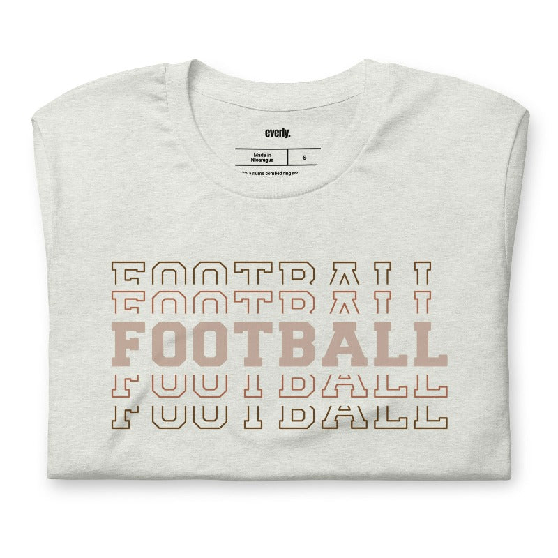 "FOOTBALL" repeated in different shades of brown and tan, with each instance of the word displayed in a slightly different style on a grey shirt.