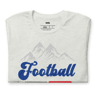 "Football," "The Perfect Sunday," and "Beer" in blue, red, and glittery blue lettering. The design includes a mountain backdrop and a goalpost, capturing the spirit of a perfect football Sunday on a white shirt.