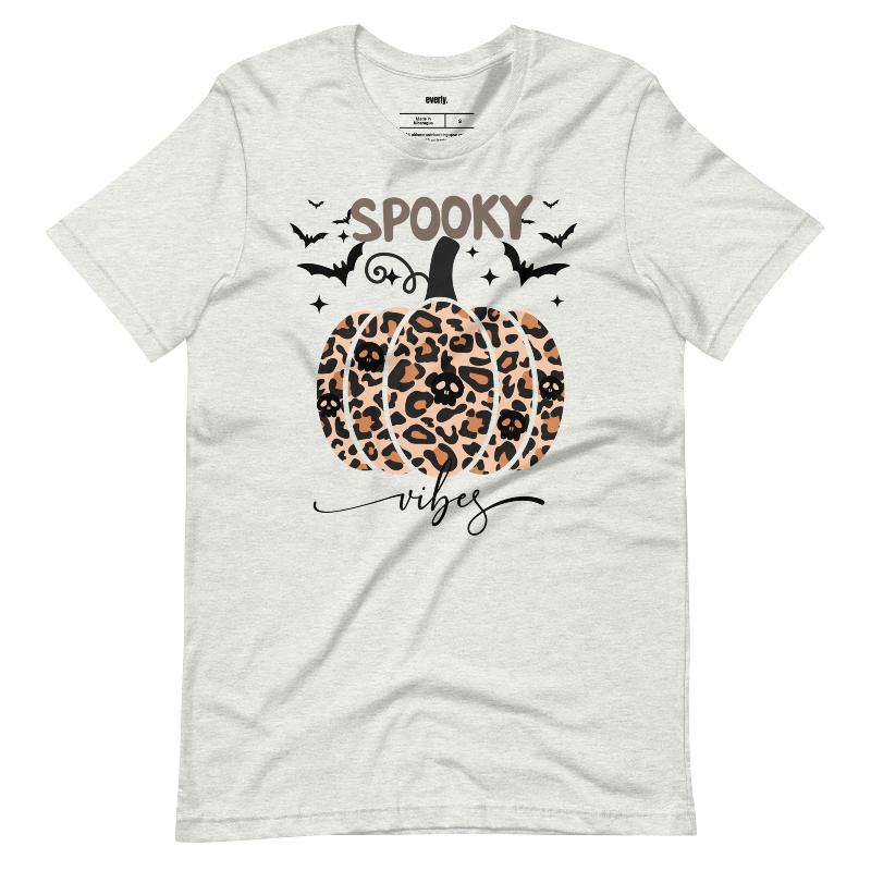 Ash t-shirt featuring a leopard-print pumpkin and "Spooky Vibes" text surrounded by bats, perfect for Halloween and fall season style.