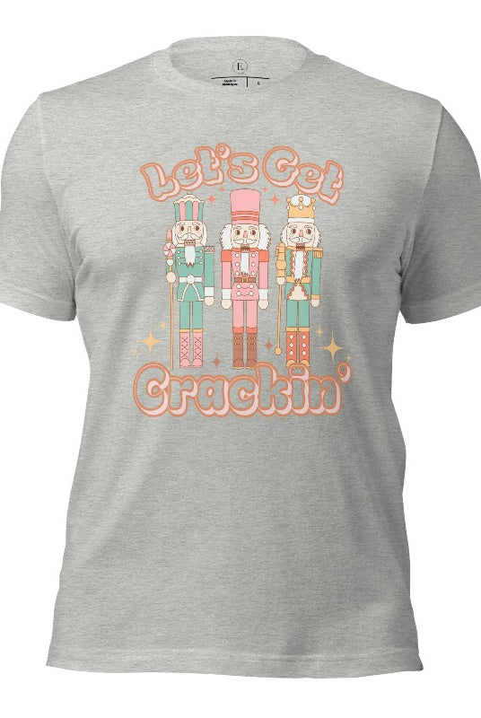Get into the festive groove with our Christmas Nutcracker shirt that exclaims, "Let's Get Crackin'!" on a athletic heather grey colored shirt. 