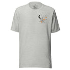Embrace the enchanting night sky with our captivating t-shirt. Featuring a crescent moon, stars, and a spiderweb with three adorable spiders hanging down on the front pocket on an athletic heather grey shirt. 