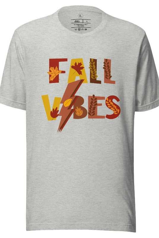 Get into the autumn spirit with our Fall Vibes shirt. Featuring the words 'Fall Vibes' with a creative twist- a lighting bolt replacing the 'I'- this shirt captures the energy of the season. Adorned with leaves, it adds a touch of nature's beauty on an athletic heather grey shirt. 