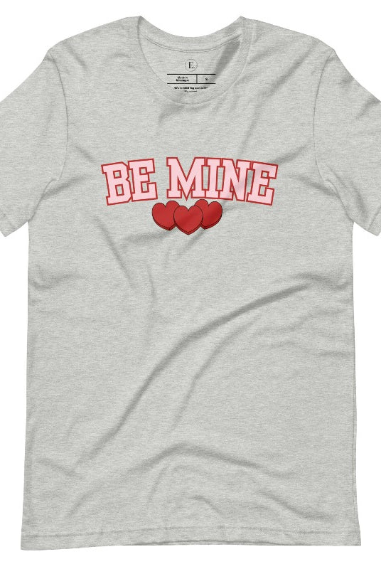 Elevate your Valentine's Day style with our "Be Mine" shirt! Featuring bold athletic lettering and three adorable hearts, on an athletic heather grey shirt. 