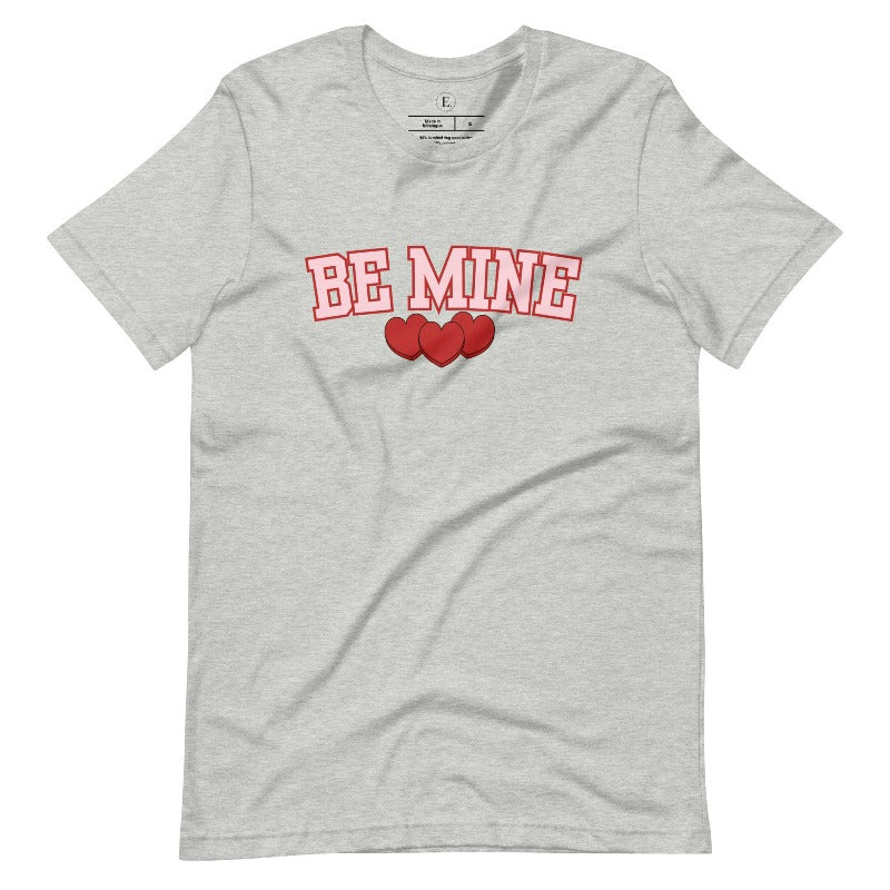 Elevate your Valentine's Day style with our "Be Mine" shirt! Featuring bold athletic lettering and three adorable hearts, on an athletic heather grey shirt. 