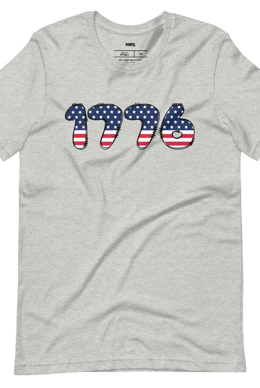 Close-up image of a USA July 4th graphic tee with the number '1776' spelled out in American flag inspired numbers on the front. This patriotic tee is perfect for celebrating Independence Day in style and showing off your love for America on an athletic heather grey tee. 
