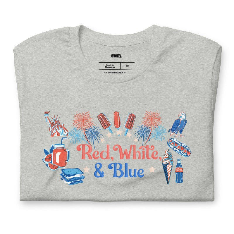 A vibrant graphic tee for the USA July 4th celebration featuring the text "Red White Blue" in bold and patriotic colors. The design is filled with various images associated with July 4th, including fireworks, American flags, stars, and stripes, evoking a sense of national pride and celebration on a grey graphic tee.