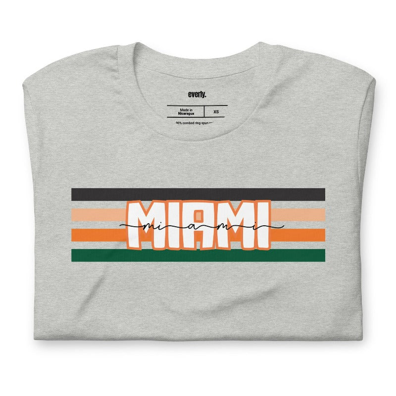 Bella + Canvas 3001 unisex t-shirt featuring the University of Miami design with black, orange, and green stripes and "Miami" text in the center on a grey shirt.