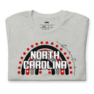 This vibrant NC State design with "North Carolina" text, rainbow arch, and red dots on a grey shirt.