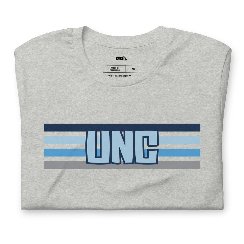 The letters "UNC" in bold blue over blue and white stripes for the University of North Carolina on a grey shirt.