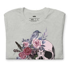 A Halloween-themed design with a skull adorned with flowers and a raven, accompanied by the text "Be Original." The shirt is soft and perfect for celebrating Halloween in style on a grey shirt.