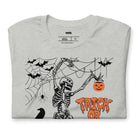 Grey t-shirt with a fun Halloween design featuring a skeleton, pumpkins, bats, and "Trick or Treat" text in a festive orange and black theme.