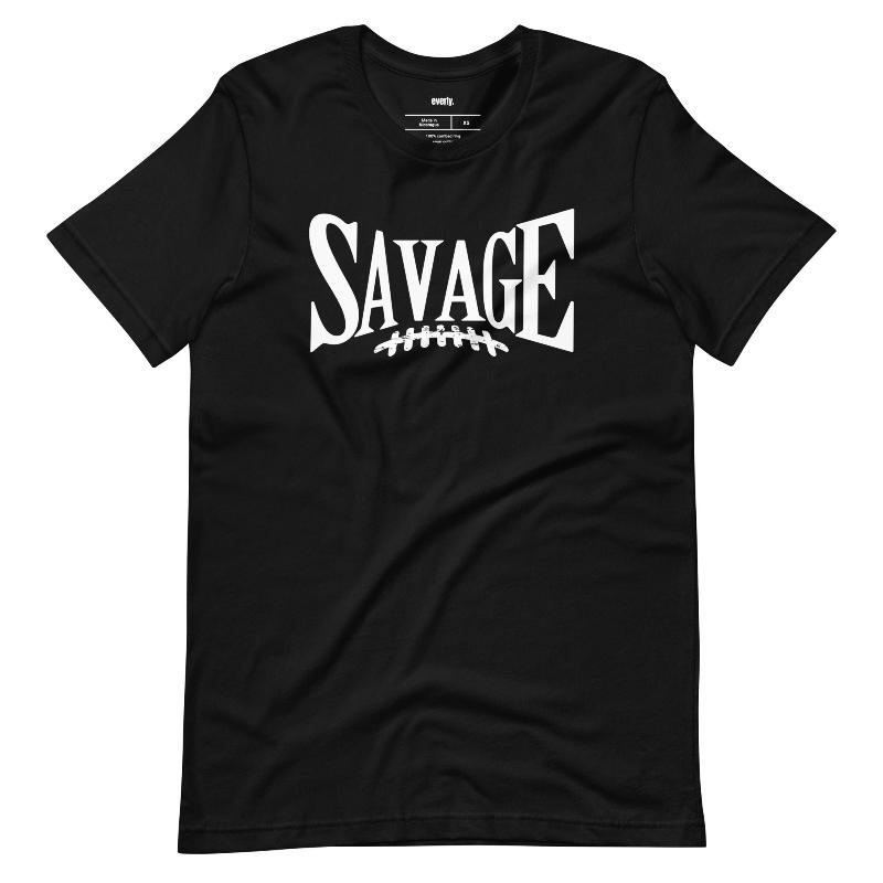 "Savage" in large, bold white letters with a football graphic underneath. The shirt is from Bella + Canvas and is made of 100% combed and ring-spun cotton on a black shirt