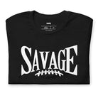 "Savage" in large, bold white letters with a football graphic underneath. The shirt is from Bella + Canvas and is made of 100% combed and ring-spun cotton on a black shirt