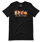  'Tis The Season' design with fall-themed graphics including a cupcake, maple leaf, football, and pumpkin, surrounded by falling leaves on a black shirt. 