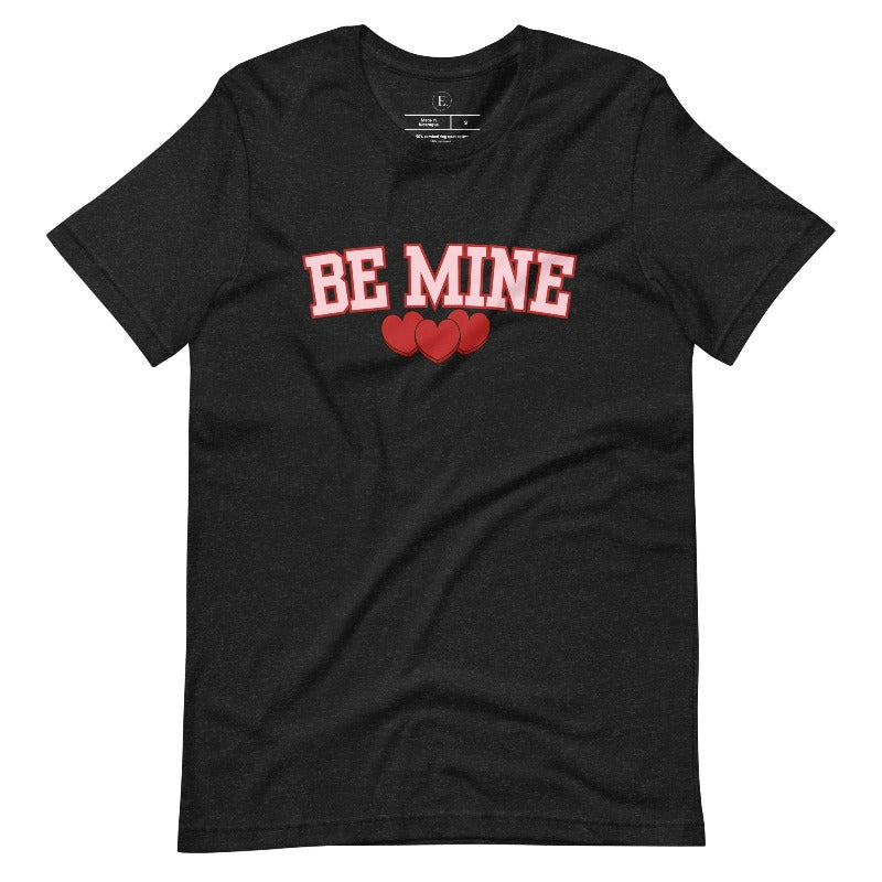 Elevate your Valentine's Day style with our "Be Mine" shirt! Featuring bold athletic lettering and three adorable hearts, on a black shirt.