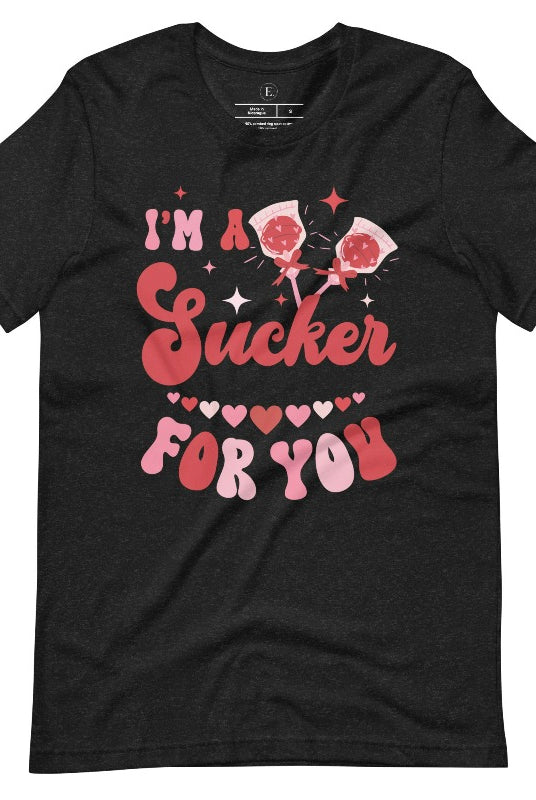 Indulge in the spirit of love with our Valentine's Day shirt! Adorned with charming Valentine lollipops and the playful saying, "I'm a sucker for you," on a heather black shirt. 