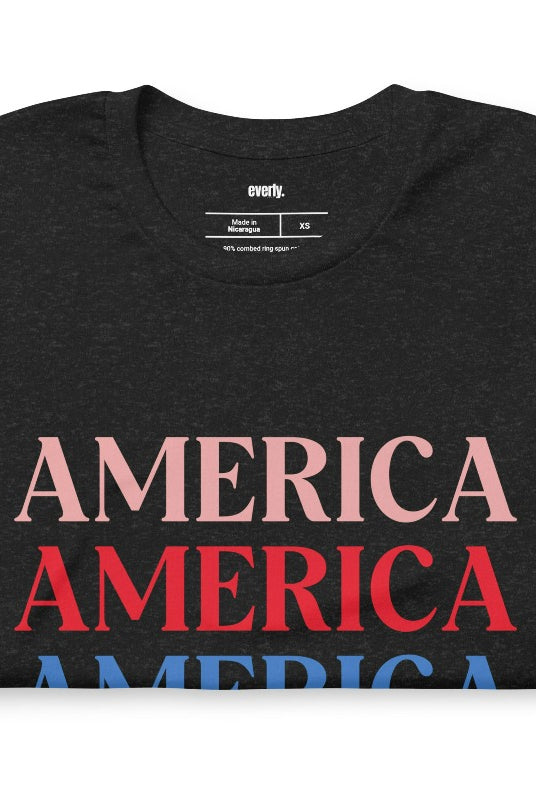 Close-up image of a USA July 4th graphic tee with the word 'America' repeated three times in bold lettering on the front. This festive tee is perfect for celebrating Independence Day in style and showing off your patriotic spirit on a black graphic tee. 