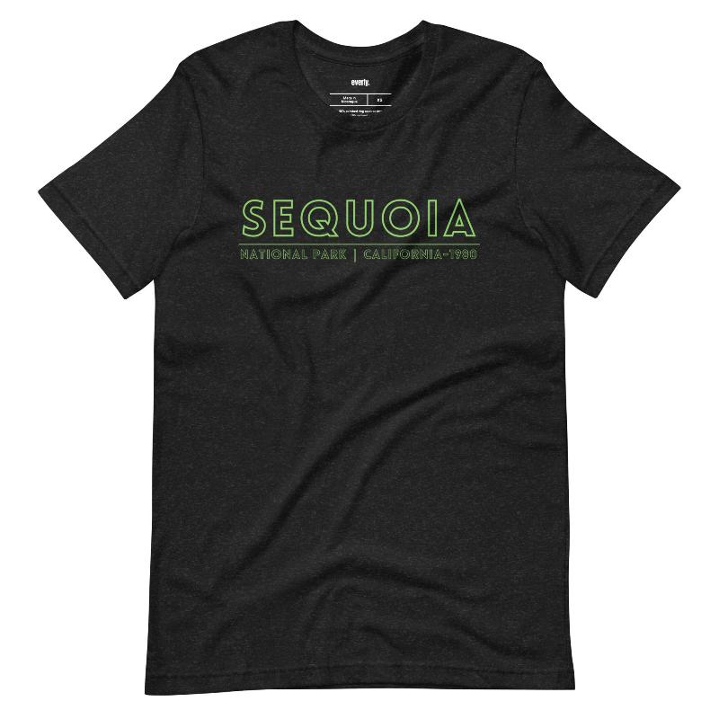 a colorful, detailed graphic of Sequoia National Park with the park's name and established year on the back, and a simplified text logo on the front on a black shirt.