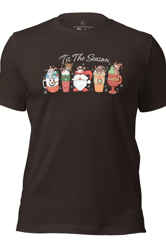 Wrap yourself in cozy holiday vibes with our Christmas coffee cup shirt. With a festive design that says "Tis The Season," this shirt captures the essence of warmth and joy on this brown colored shirt. 
