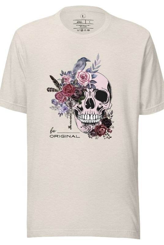 Looking for a unique Halloween shirt? Look no further! Our hauntingly beautiful shirt features a floral skull, raven, and the empowering slogan 'Be Original'. Stand out from the crowd with this unforgettable statement piece on a heather dust colored shirt. 