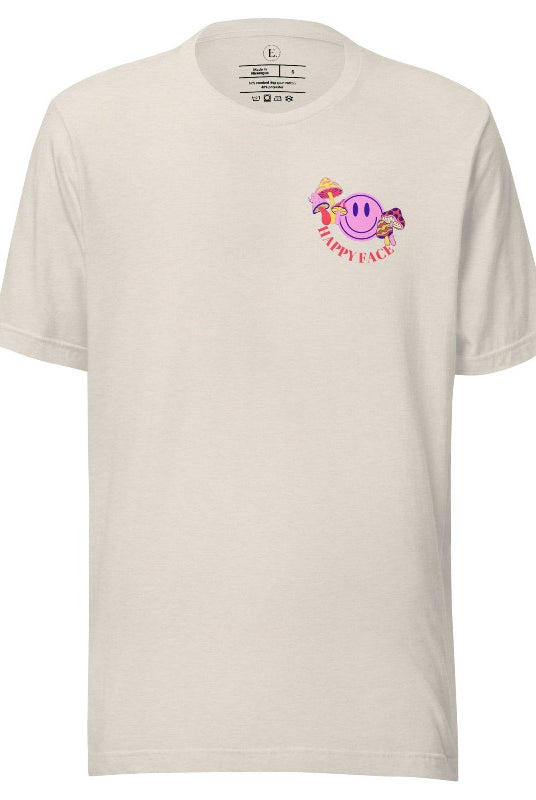 Spread positivity with our delightful t-shirt. The design features a happy face with mushrooms on the side and the words 'Happy Face' on the front pocket on a heather dust colored shirt. 
