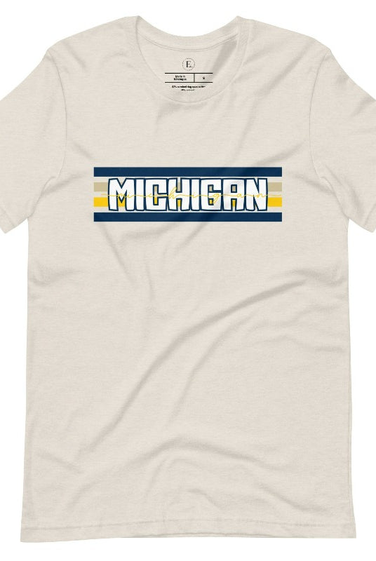 Elevate your collegiate style with our Michigan University graphic tee featuring iconic school colors and bold chest stripes. Emblazoned with "Michigan" in striking lettering, on a heather dust colored shirt. 