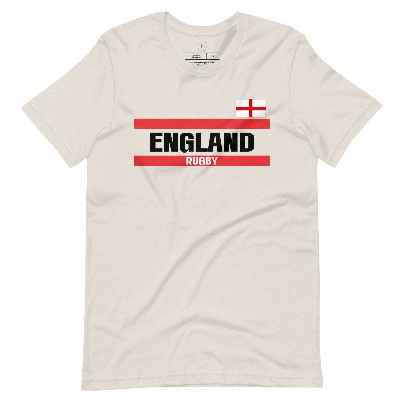 Introducing our England Rugby Graphic T-Shirt - made for rugby fans who want to show off their pride in a stylish and contemporary way! Featuring the words "England Rugby" and the iconic England flag, on a heather dust colored shirt. 