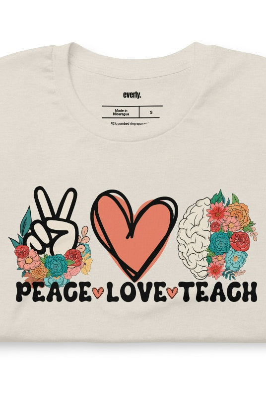 Floral design featuring the words 'peace love teach' on a teacher graphic tee - a great choice for teacher shirts and teacher gifts. Cream graphic tees. 