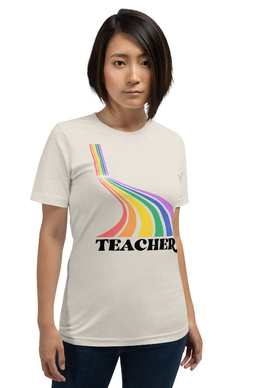 Colorful rainbow design with the word 'teacher' at the bottom, showcased on a teacher graphic tee. The perfect choice for teacher shirts and teacher gifts. Cream graphic tees.
