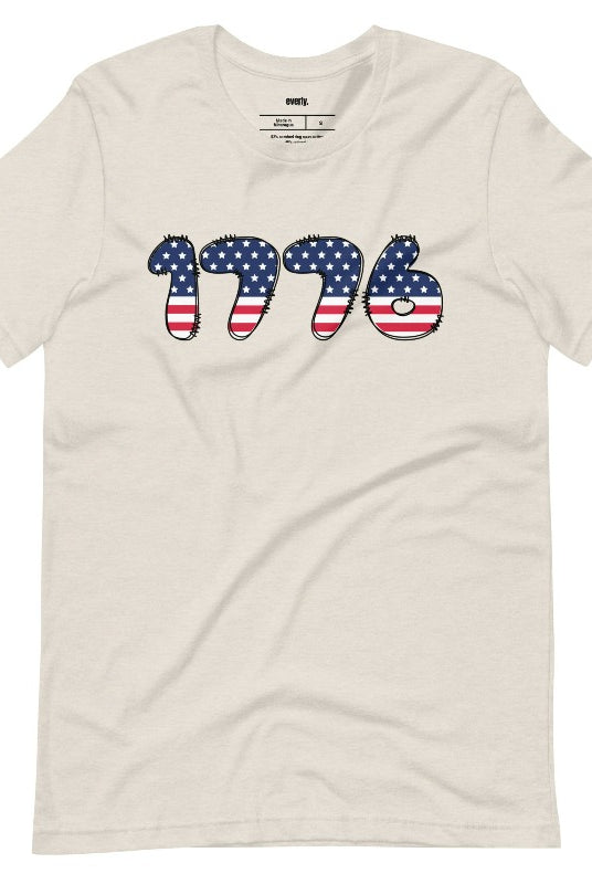 Close-up image of a USA July 4th graphic tee with the number '1776' spelled out in American flag inspired numbers on the front. This patriotic tee is perfect for celebrating Independence Day in style and showing off your love for America on a heather dust tee, 