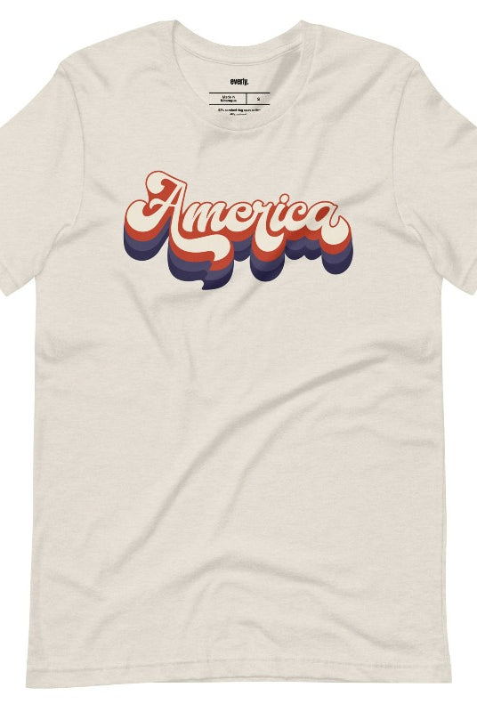 Close-up image of a USA July 4th graphic tee with the word 'America' spelled out in funky retro lettering on the front. This vintage-inspired tee is perfect for adding a fun and nostalgic touch to your Independence Day celebrations on aheather dust graphic tee. 