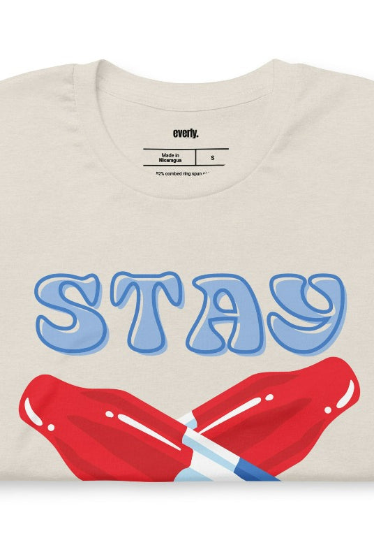 A fun and playful graphic tee for the USA July 4th celebration featuring vibrant and colorful bomb popsicles with the text 'Stay Cool' on the front. The tee captures the essence of summertime and the festive spirit of July 4th, making it a perfect choice for a cool and refreshing look on a heather dust graphic tee.