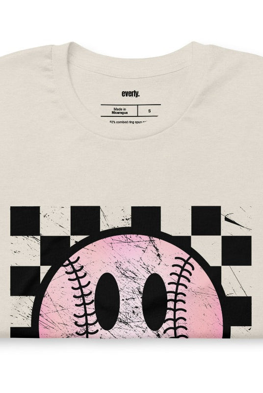 Retro softball smiley face on a heather dust graphic tee.