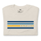 Bella + Canvas 3001 unisex t-shirt featuring bold blue and gold horizontal stripes with the word "CALIFORNIA" prominently displayed in the center on a beige shirt.