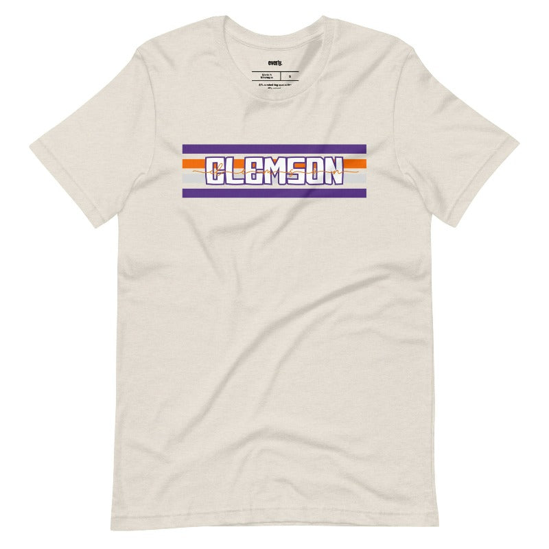 Bella + Canvas 3001 unisex shirt with Clemson University stripe design in purple, orange, and white, with "Clemson" written in bold letters on a beige graphic tee.