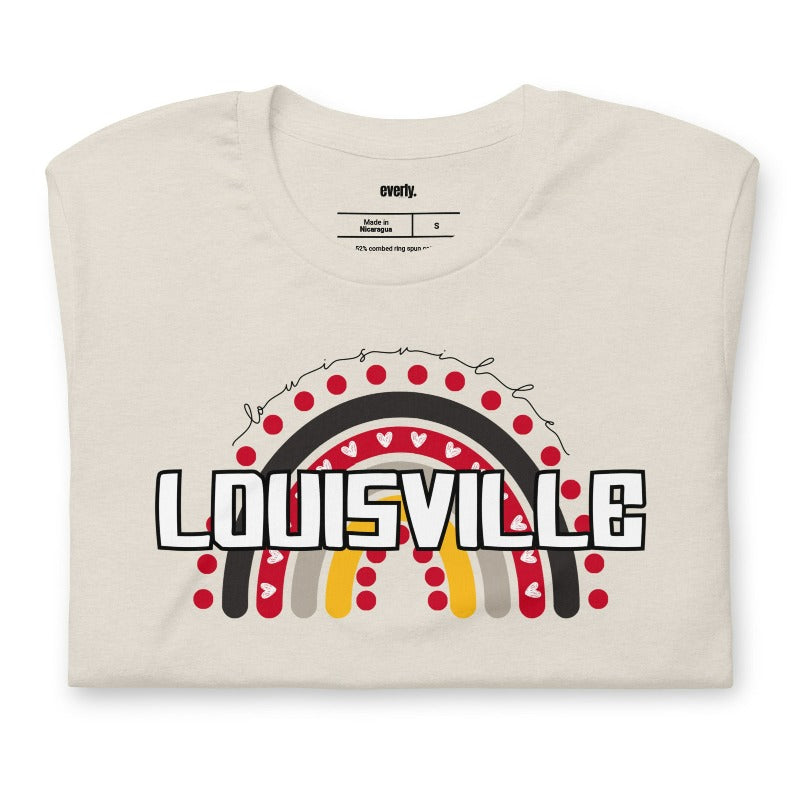 A vibrant rainbow design and the text "Louisville" in bold letters, perfect for showing University of Louisville spirit on a beige shirt.