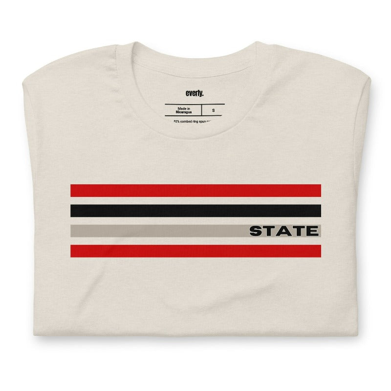 Bold red, black, and grey stripes with "STATE" text for NC State on a beige shirt.