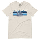 Serene Chapel Hill pine tree design with "North Carolina" and blue and white stripes on a beige graphic tee.